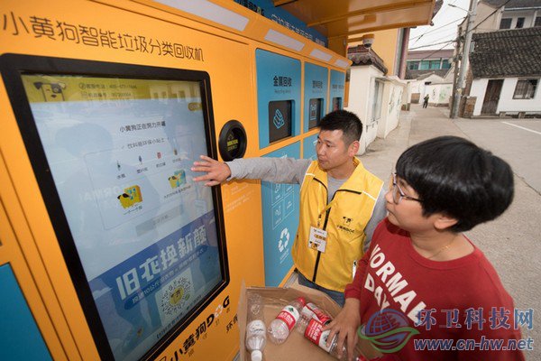 10月30日，在道場(chǎng)鄉(xiāng)錢(qián)山下村，工作人員（左）指導(dǎo)村民在智能回收機(jī)上進(jìn)行垃圾分類回收。