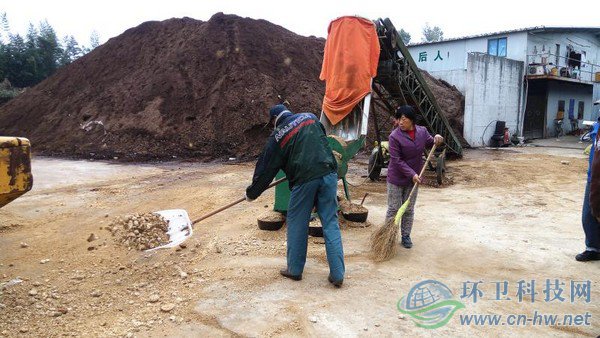 工人將機器碾碎的園林廢棄物鏟入發(fā)酵堆，噴灑生物菌劑攪拌后，自然發(fā)酵兩到四個月，就能成為有機介質(zhì)，用來改良土壤